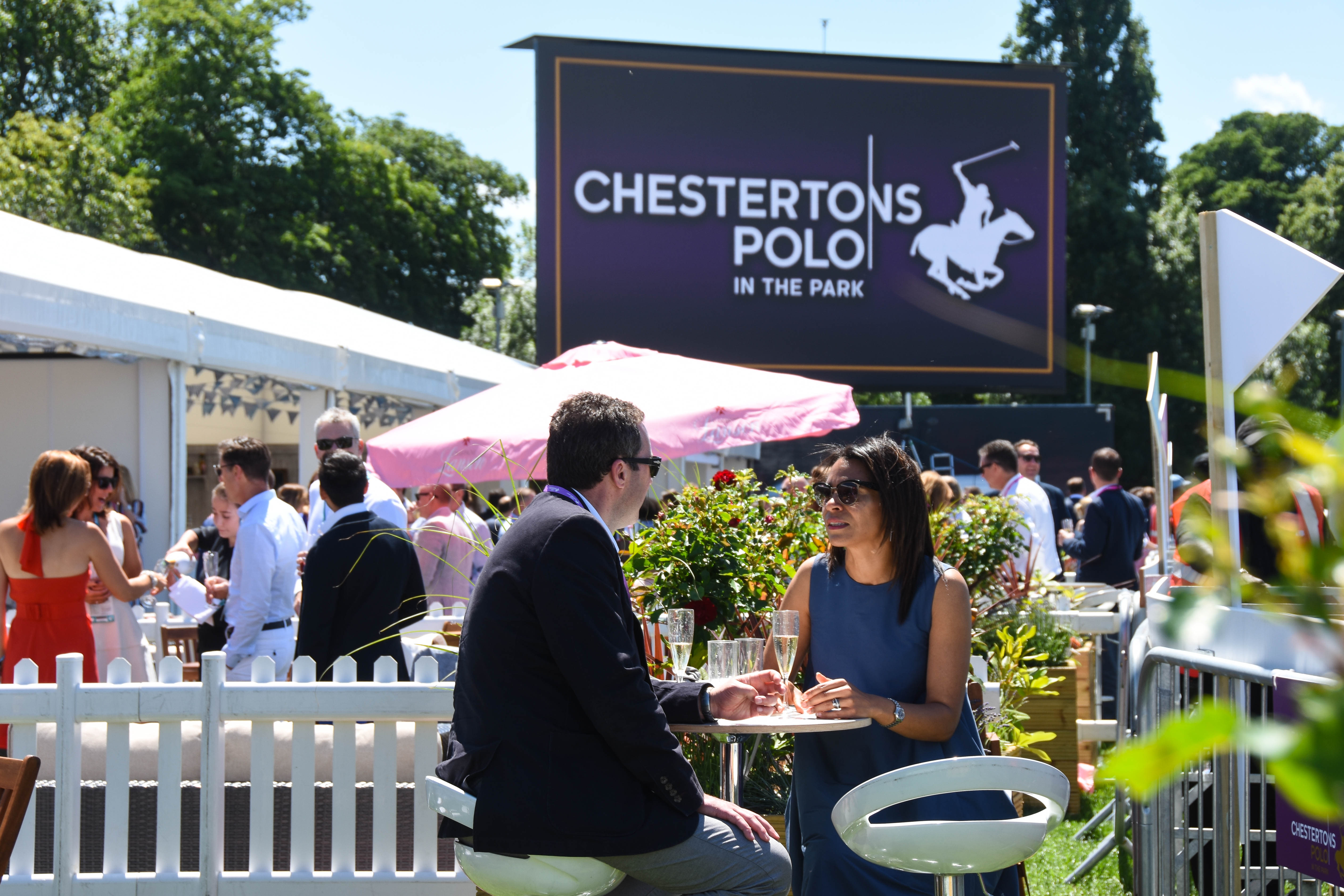 Guests dressed in smart casual attire at Chesterton Polo in The Park. 