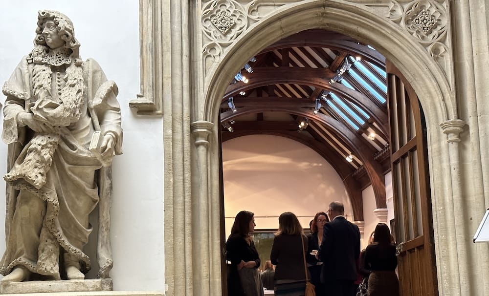 Statue and small group of people talking at the The Beacon Collaborative's annual Philanthropy and Impact Forum in Guildhall, London