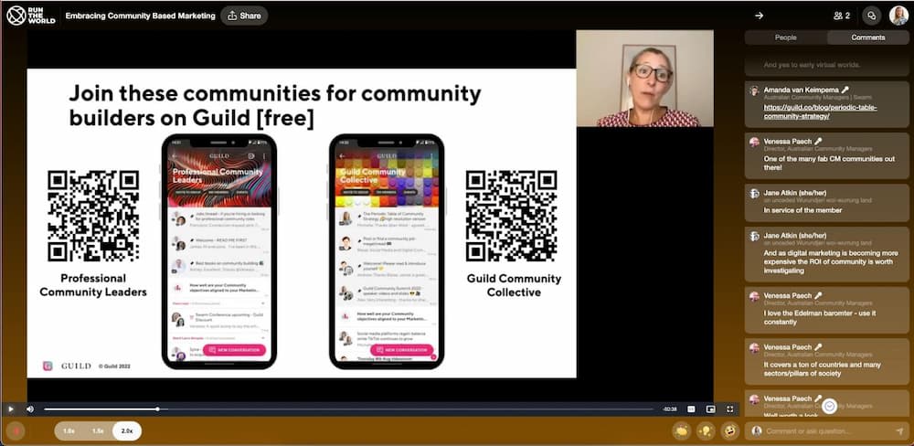 A screenshot of Michelle Goodall speaking at a virtual conference with mobile phones showing a Guild community and QR codes