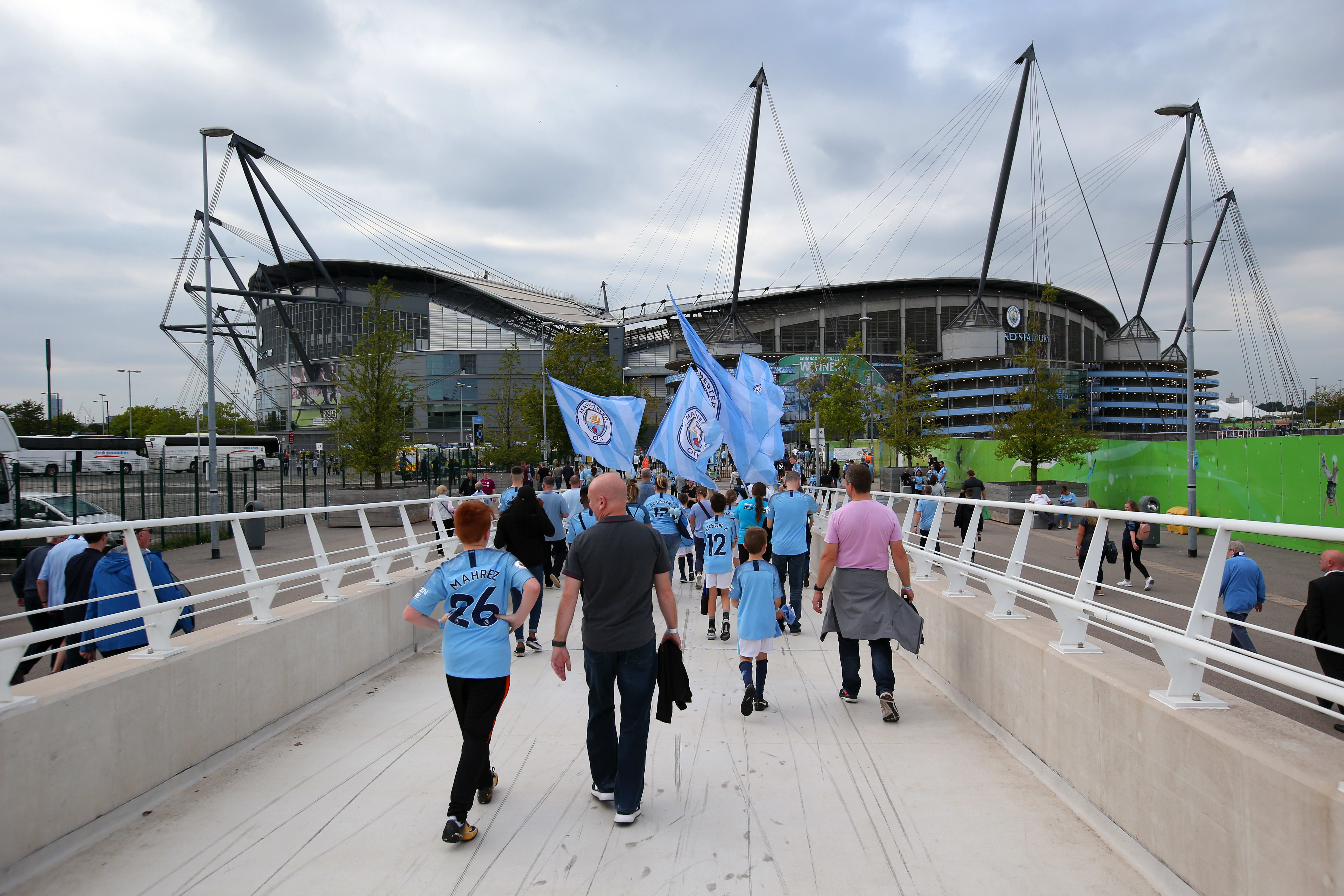 Manchester City fans walking toward the Etihad Stadium