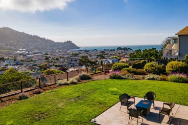 Spacious outdoor seating with table, chairs, and a beautiful ocean view