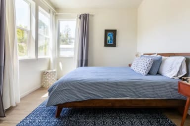 Queen bed in the front bedroom with a garden view