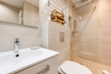 Salle de bain design avec douche, chauffe serviettes, gel douche, shampoing,...