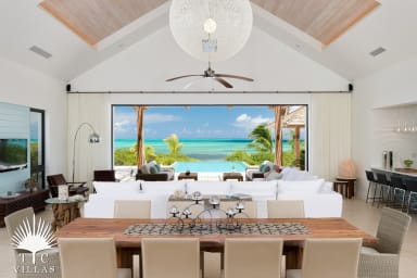 Large living room with dining table for 10, large couch, TV, and pool access.