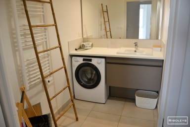Salle de bain avec douche et machine à laver