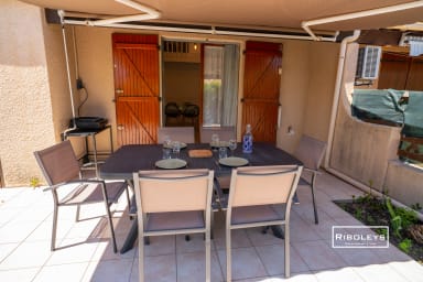 Terrasse extérieure avec plancha électrique, table à manger, store banne.