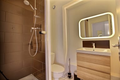 salle de bain avec douche, porte serviettes chauffant, lavabo et WC