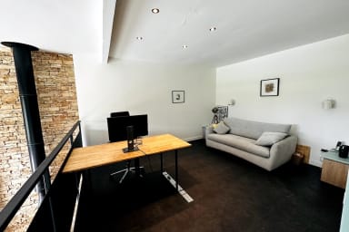Mezzanine avec post de travail et écran d'ordinateur. Le canapé est un...