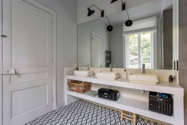 Troisième salle de bain équipée de trois vasques, d'une douche et d'une...
