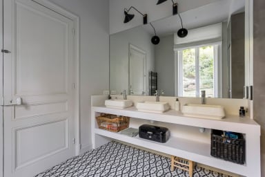 Troisième salle de bain équipée de trois vasques, d'une douche et d'une...