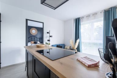 Une pièce à vivre avec cuisine ouverte et grande fenêtre pour illuminer la pièce