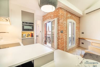 Cuisine équipée avec fenêtre donnant sur les toits de Toulouse