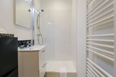 Salle d'eau avec douche, sèche-cheveux, et toilettes