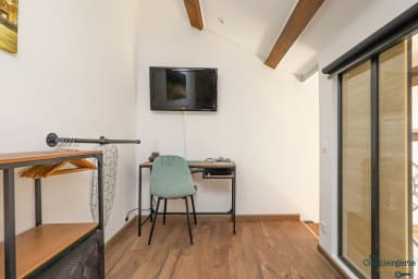 Chambre à coucher avec espace bureau et télévision