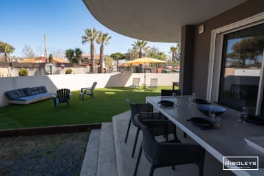 Grand espace extérieur équipé de salons de jardin et de bains de soleil.