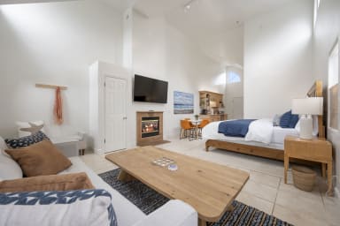 Cozy king bedroom featuring sofa, center table, TV, and inviting fireplace
