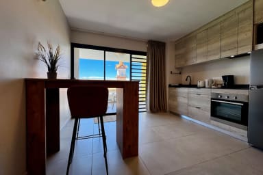 Tableau haute avec deux tabourets. Cuisine équipée.