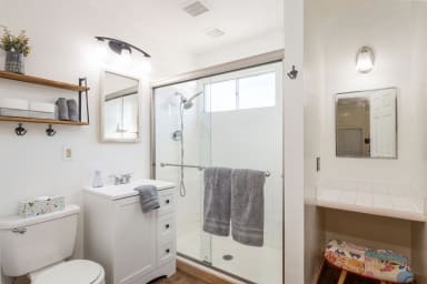 Bathtube, toilette, mirrors, towels, drawers, sink