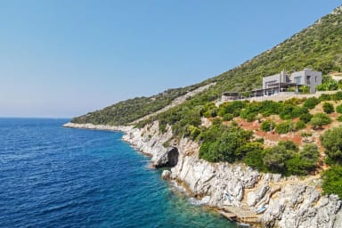 Villa façade stands boldly above the coastline, promising a scenic escape.