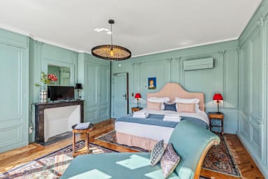 Suite élégante avec lit double, coin TV et touches traditionnelles raffinées.
