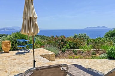 Détente sur la terrasse ensoleillée face aux jardins verdoyants et à la mer