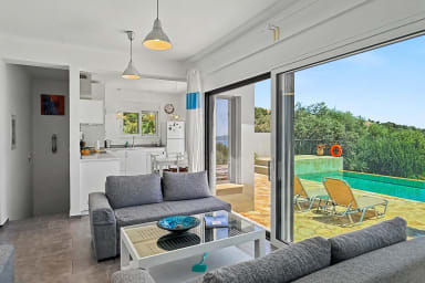 Espace salon-salle à manger avec vue sur piscine privée et jardin.