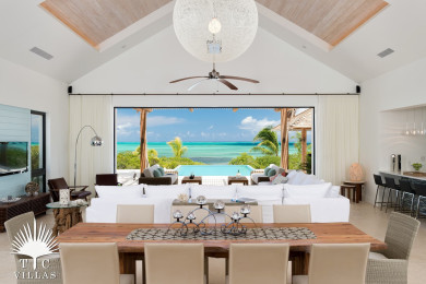 Large living room with dining table for 10, large couch, TV, and pool access. 