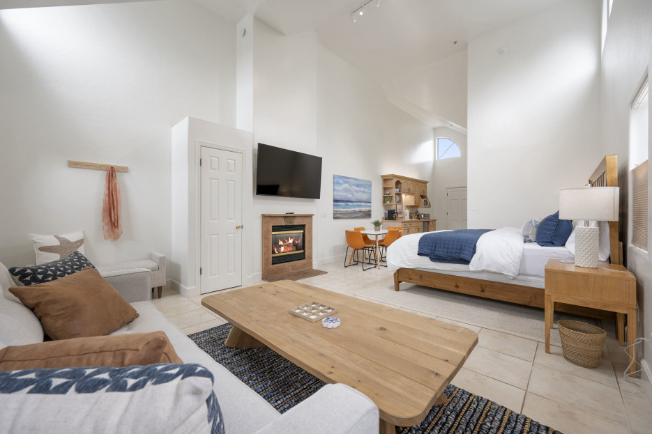 Cozy king bedroom featuring sofa, center table, TV, and inviting fireplace