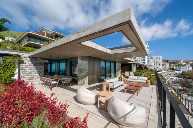 Terraço com canteiros floridos e vista sobre a cidade