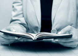 Person opening a book with the DBS information