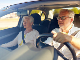 Ein älteres Paar, das mit dem Auto fährt.