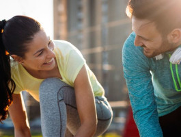 Mann und Frau schnüren Schuhe zum Joggen.