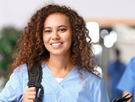 Eine junge Frau in Kasak, Rucksack und Klemmbrett.