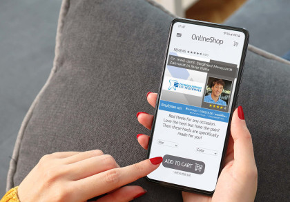 Eine Hand hält ein Smartphone, das eine Online-Shop-Seite anzeigt. Die Seite wirbt für rote Schuhe. Über der Werbung befindet sich ein Werbebanner für einen Zahnarzt namens Dr. med. dent. Siegfried Marquardt, der in der Nähe ist.