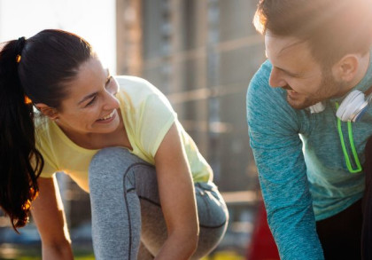 Mann und Frau schnüren Schuhe zum Joggen.