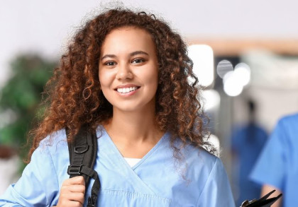 Eine junge Frau in Kasak, Rucksack und Klemmbrett.