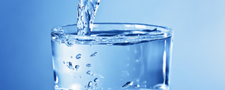 Ein klares Glas wird mit frischem, sauberem Trinkwasser gefüllt – Symbol für Wasserqualität, Gesundheit und moderne Wasserfilterung im Alltag.