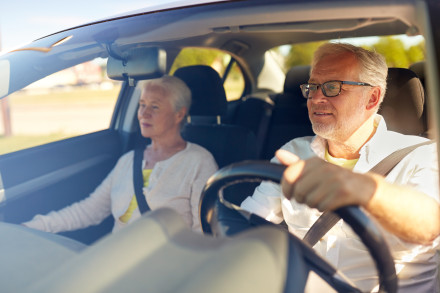 Ein älteres Paar, das mit dem Auto fährt.