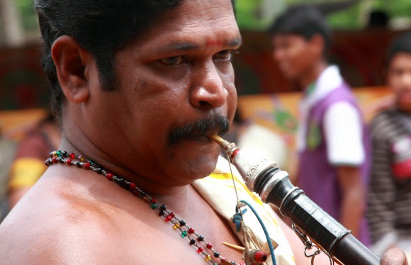 Ein Mann spielt Musik während des Onam Festes in Kerala, Indien