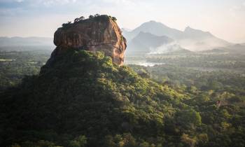 a view of a rocky mountain with trees in the background