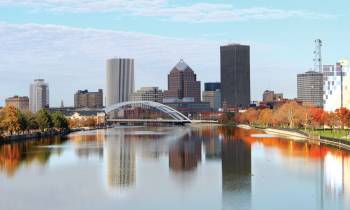 a bridge over a body of water with a city in the background