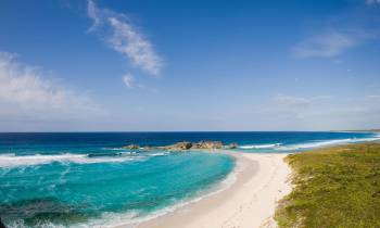 a sandy beach next to a body of water