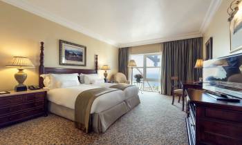 a bedroom with a bed and desk in a hotel room