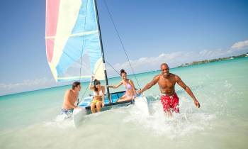 a group of people riding on the back of a boat in the water