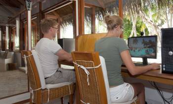 a person sitting on a chair in front of a laptop