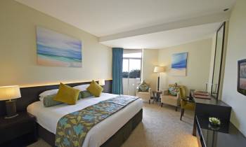 a bedroom with a bed and desk in a hotel room