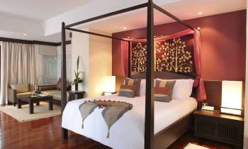 a bedroom with a bed and a chair in a room