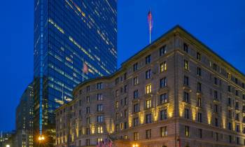 a lit up city at night with The Fairmont Copley Plaza Hotel in the background