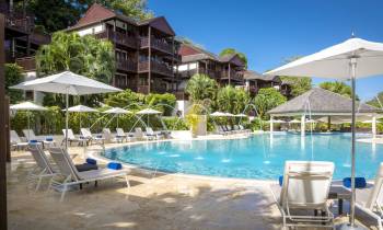 a group of lawn chairs sitting next to a pool of water