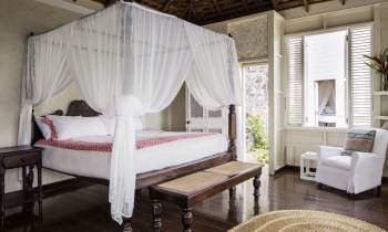 a bedroom with a bed and a chair in a room